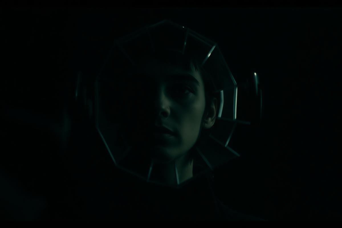 A cracked mirror reflecting a shadowed face in dramatic side light