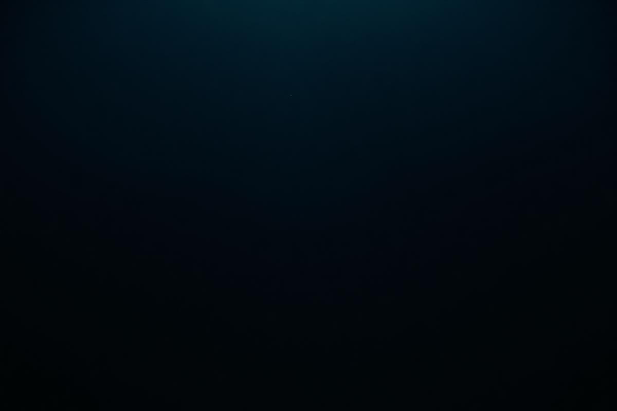 Dark still water with faint light beneath the surface